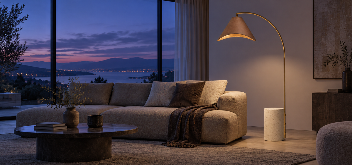 Warm arc floor lamp beside a sofa at dusk